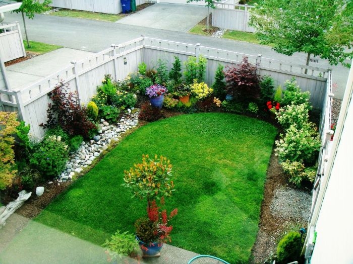 cloture de jardin avec gazon au milieu et des fleurs et arbustes en bordure idee amenagement jardin facile