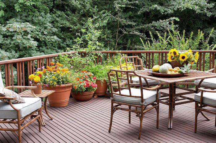 comment aménager sa terrasse en bois composite avec gros pots de fleurs chauses et table bois