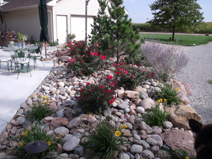 comment décorer son espace devant maison avec un massif de fleurs avec des pierres en couleurs differents