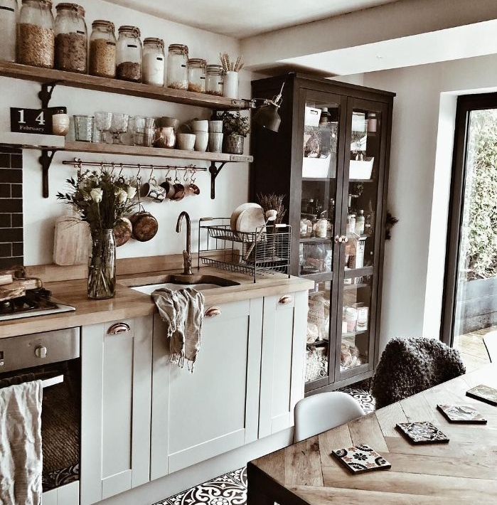 cuisine ancienne moderne avec meuble bois gris clair carrelage cerame vaisselier noir table et étagères ouvertes bois