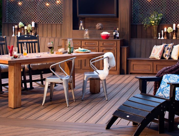 cuisine exterieure d été sur terrasse bois composite avec chaise longue et table bois et des chaises en métal