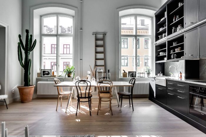 deco appartement haussmannien avec cuisine couleur noire ouverte sur salle à manger dans appartement parisien aux murs blancs