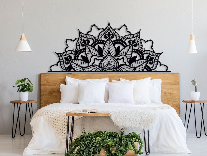 decoration murale mandala noir au dessus d un lit entre deux plantes
