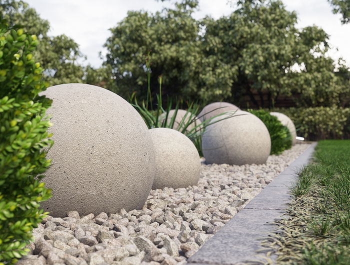 des pierres rondes enormes décoratives dans un jardin sur une surface couverte de gravier