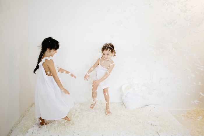 deux enfants qui jouent sur un matelas entours de pouf