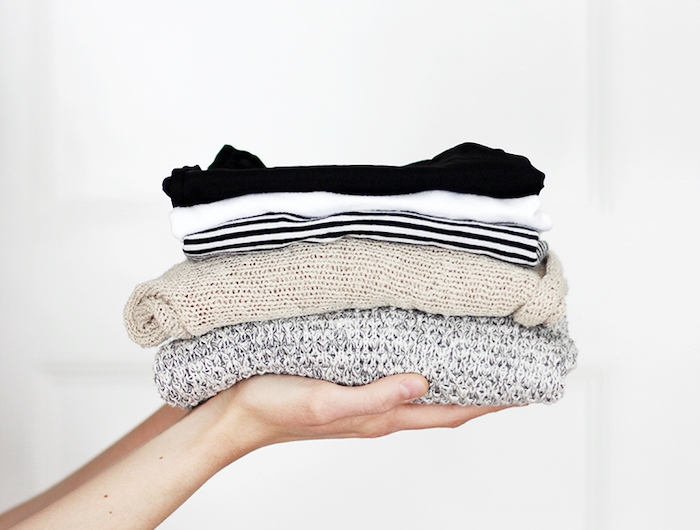 deux mains qui tiennent des blouses tricotés pliés elements d un style minimaliste femme