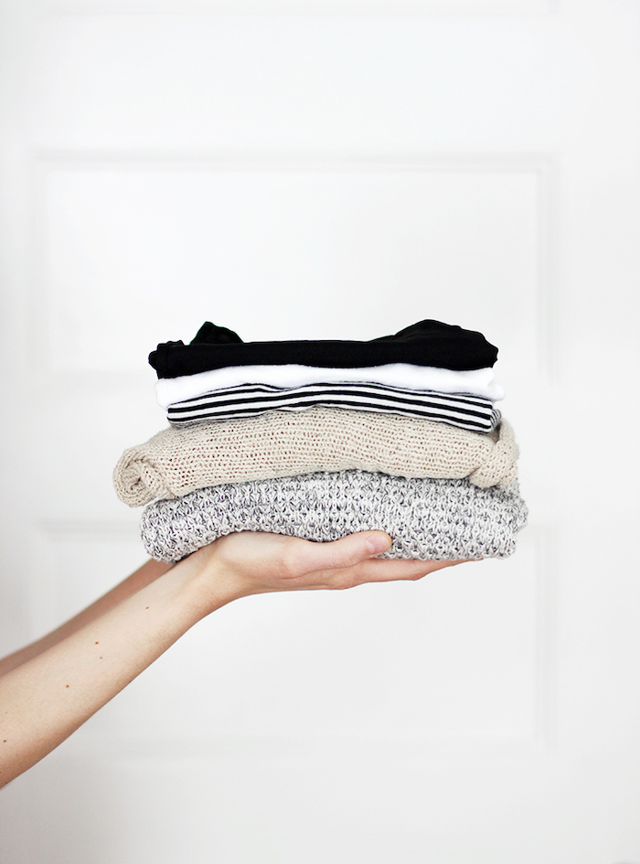 deux mains qui tiennent des blouses tricotés pliés elements d un style minimaliste femme