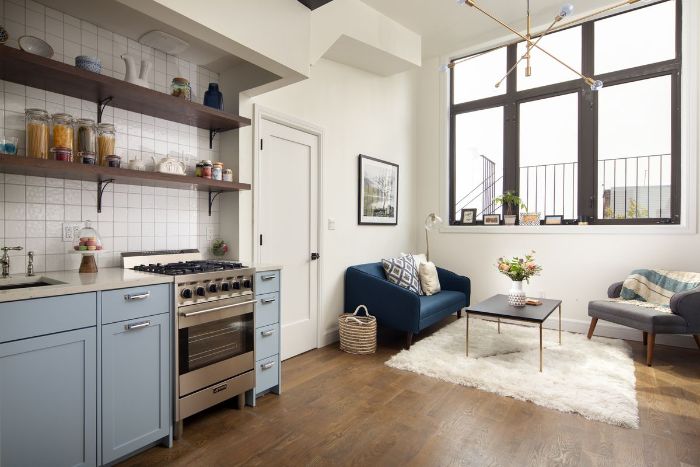 exemple cuisine americaine ouverte sur petit salon canapé deux paces bleu et fauteuil gris table basse cuisine bleu de gris deco