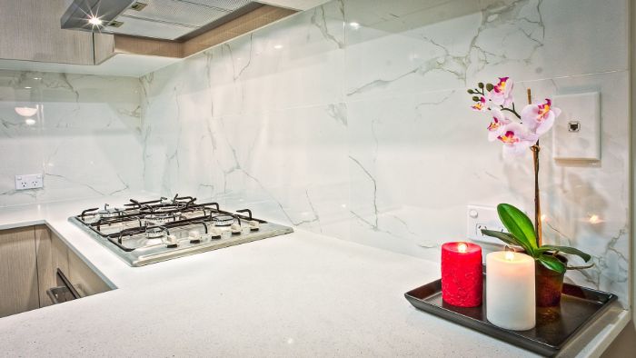 exemple de credence cuisine en marbre balnc dans une cuisine au plan de travail blanc et façade bois clair