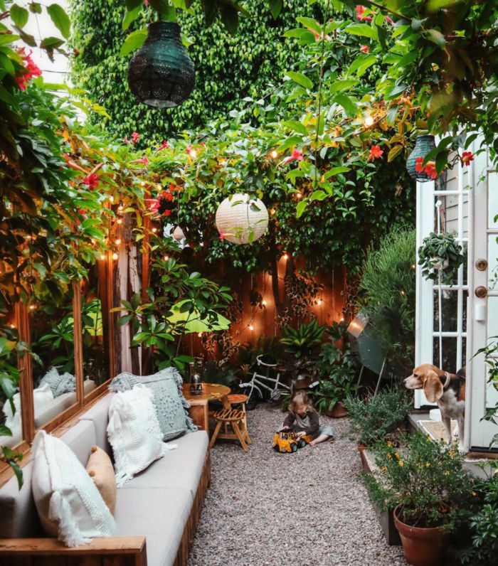 idée comment aménager un petit jardin de 10 m2 avec banc en bois végétation verte palissade guirlande lumineuse parterre de gravier