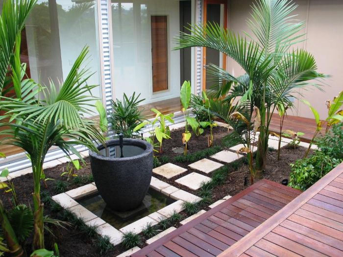 idée pour aménager un petit jardin de 20 m2 avec terrasse en bois chemin de dalles au milieu de plantes vertes