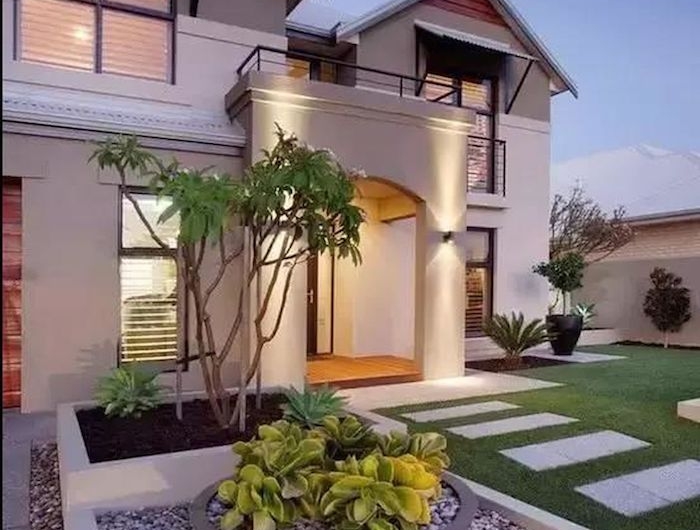 maison ultra moderne avec de pelouse devant et un carré décoratif rempli des cailloux