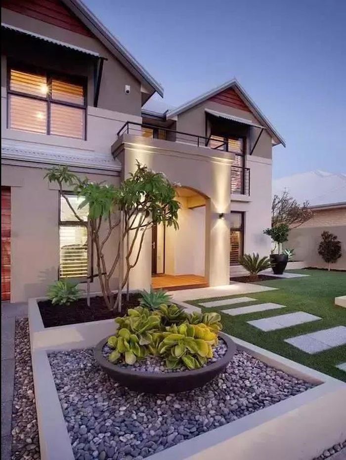 maison ultra moderne avec de pelouse devant et un carré décoratif rempli des cailloux