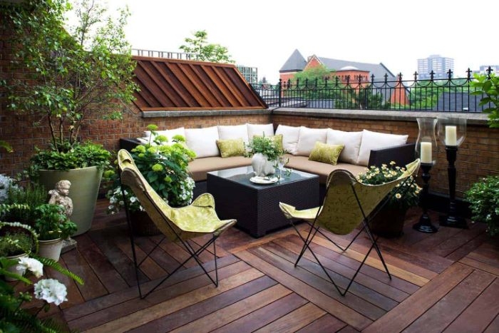 modele de terrasse de toit avec canapé d angle et table tressée chaise pliantes pantes et fleurs en pot