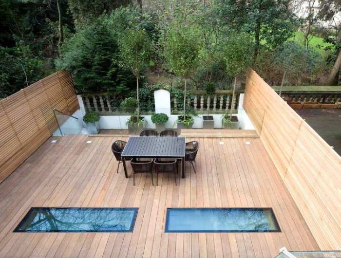 modèle terrasse bois en hauteur avec chaises tressées table salle à manger sol bois plantes en bacs de béton