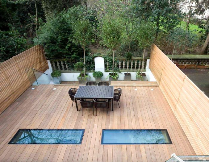 modèle terrasse bois en hauteur avec chaises tressées table salle à manger sol bois plantes en bacs de béton
