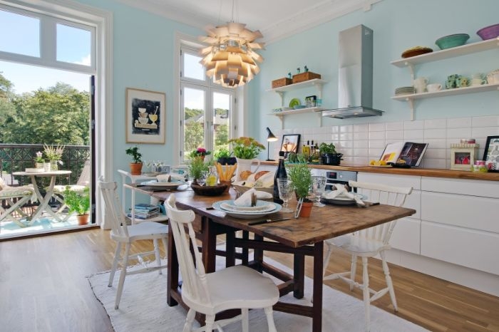 peinture murale bleu ciel dans cuisine au carrelage blanc meuble cuisine blanc avec plan de travail bois table bois brut et chaises boisées