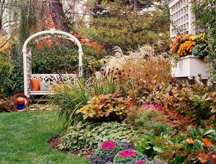 petit jardin amenagement avec parterre de fleurs plantes buis gazon en pente banc avec arche.jfif