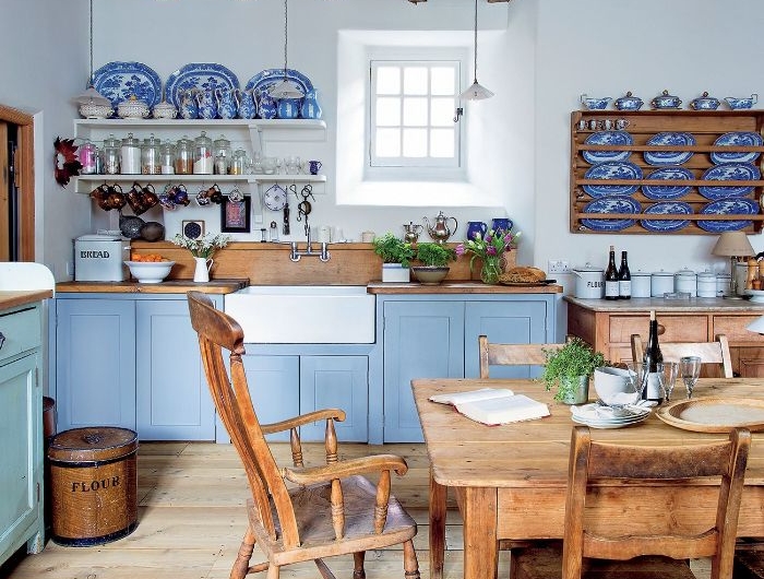 petit vaisselier mural plafond poutres chaises et table salle à manger de bois façade cuisine couleur bleue murs blancs