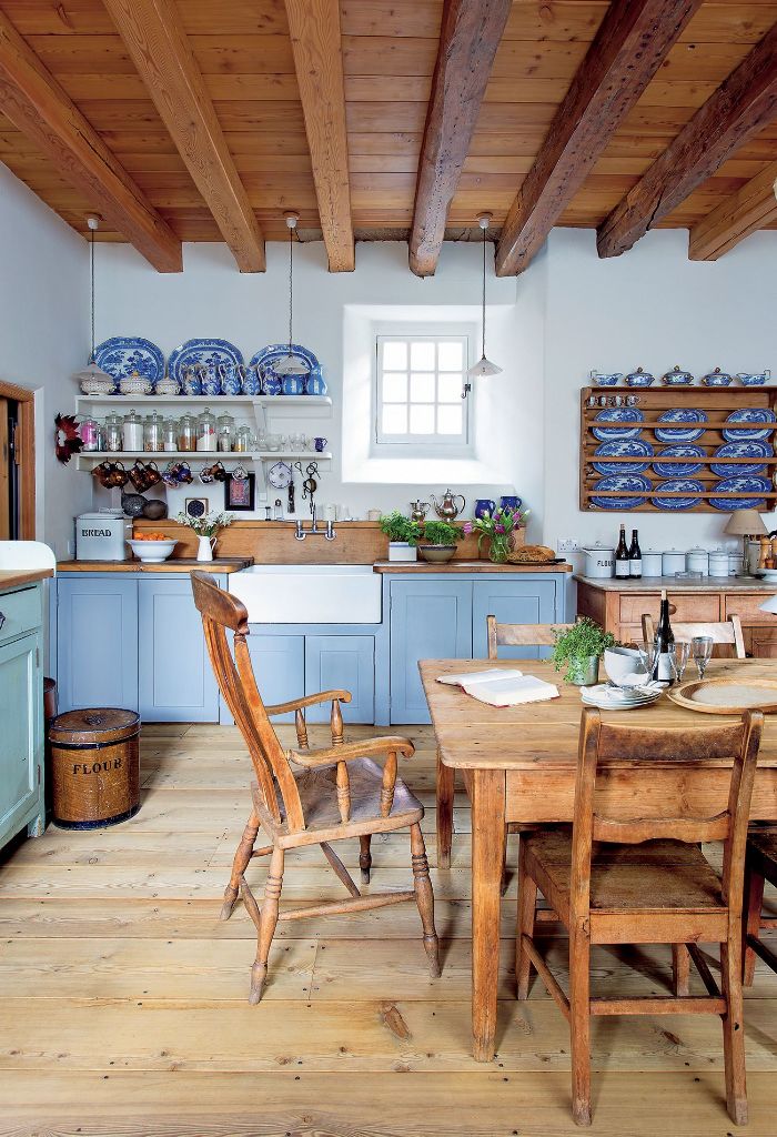 petit vaisselier mural plafond poutres chaises et table salle à manger de bois façade cuisine couleur bleue murs blancs