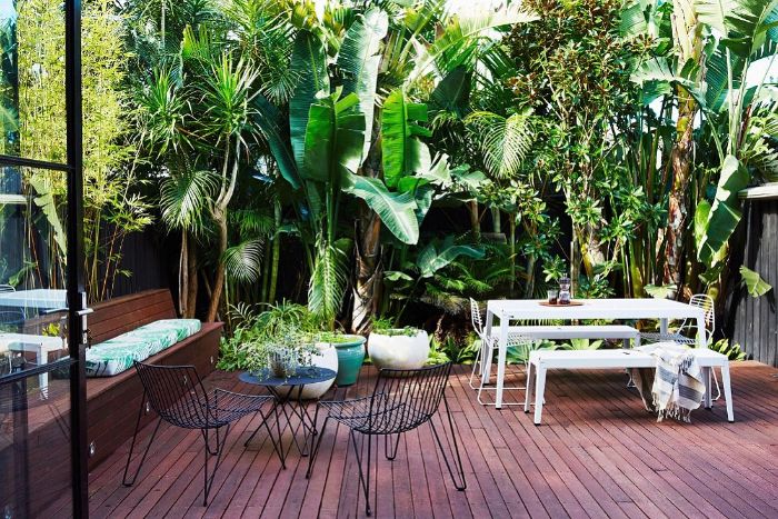 petite terrasse aménagée avec mur végétal table chaises et banc blanc table et chaise en métal plante en pot