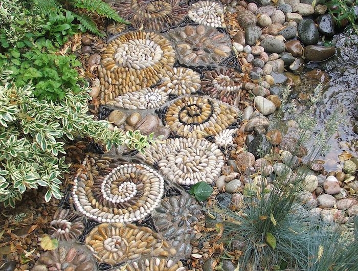 photo deco jardin avec graveir en formes artistiques spirales et des plantes vertes a deux cotés