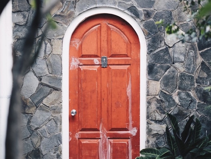 porte d entree rouge forme ovale maison en pierres