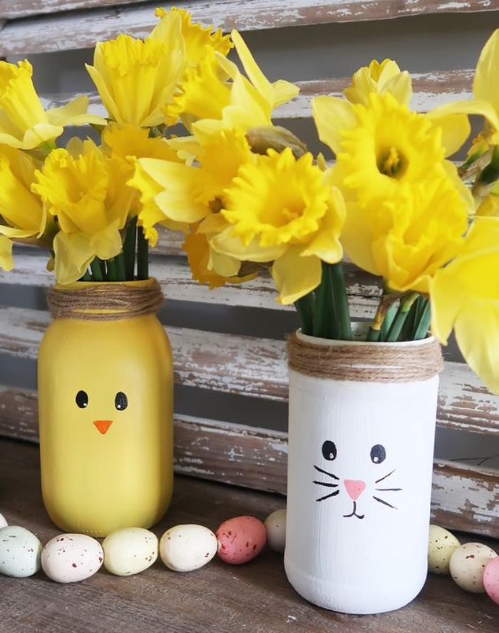 recycler des pots en verre pour fabriquer une idee deco paques pots peints motif lapin et poussin avec ficelle autour du col et des fleurs à l intérieur