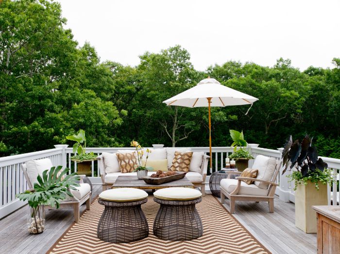 salon de terrasse en bois avec des coissins d assise gris tables orientaux deco boisée et plantes parasol terrasse aménagée