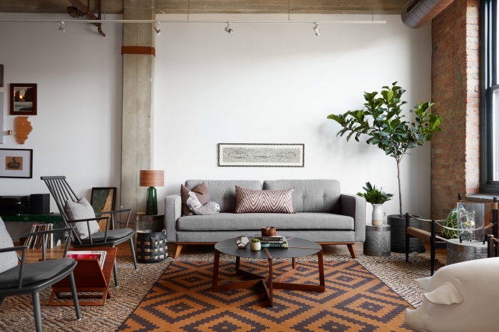 salon style industriel colonne béton chaise gris anthracite canapé gris clair mur de cadres plantes