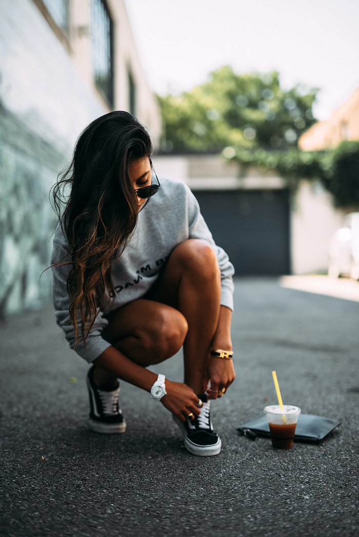 streetwear femme qui combine des sneakers vans un pull spotrif et des short noir