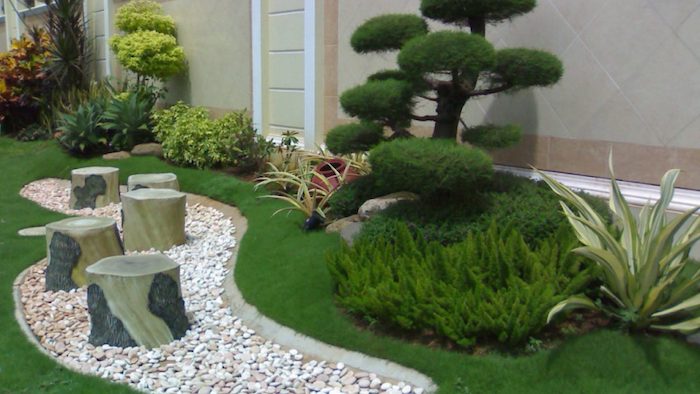 un espace vert devant maison avec des plantes diferents et création d un parterre avec galets