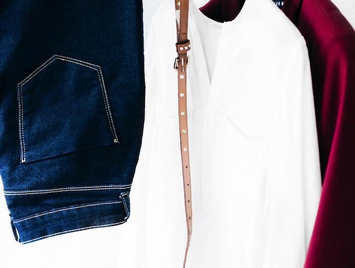 un jean chemisier blanc et veste bordeux sur des cintres garde robe minimaliste