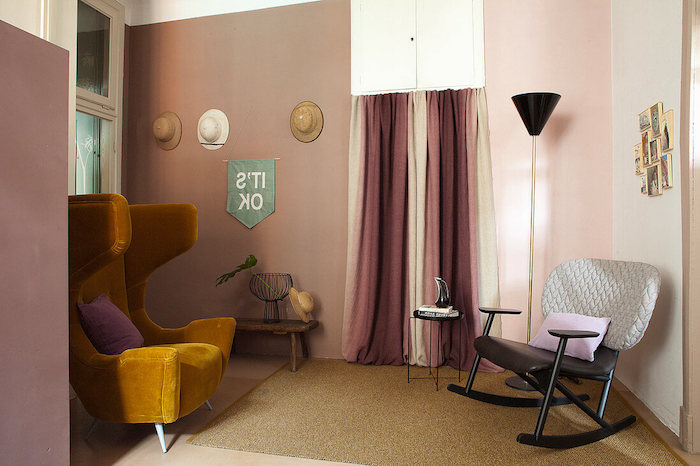 un salon avec meubles vintage des mus aux peinture beige et déco vieux rose sous la forme des rideaux