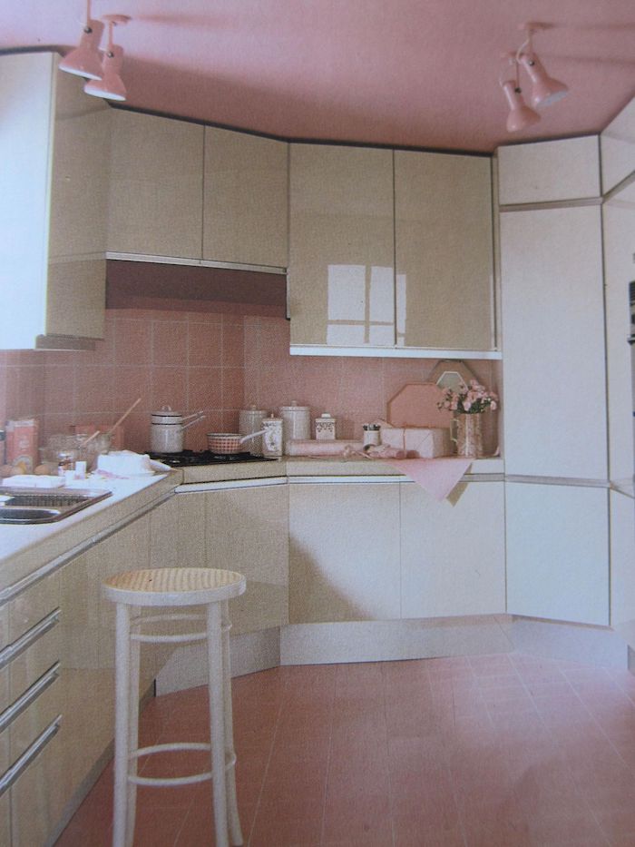 une cuisine avec placards blanc et un plaford et carrealge en couleur complémentaire rose