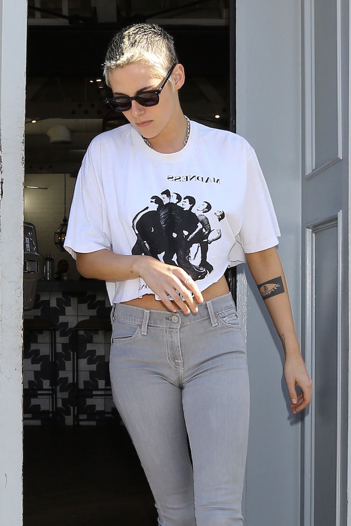 a woman wearing a cropped print T-shirt and gray jeans, an example of American fashion
