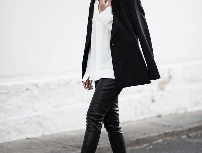 une femme en tenue style qui comporte pantalon en cuir chemisier blanc et une veste noir