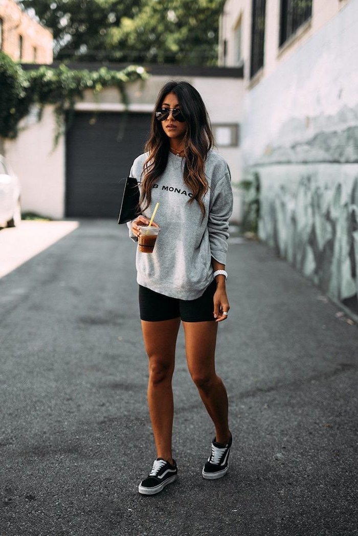 a woman wears the American brand Vans sneakers black shorts and a gray blouse