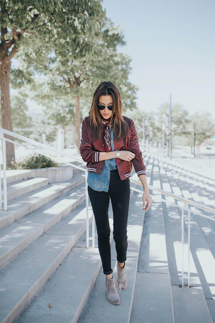 une femme qui porte des bottes gris type chelsea une veste gollegienne et chemisier en denim style américain