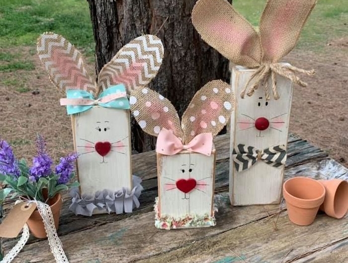 une idée de déco de paques diy avec des lapins élaborés de bois et de carton devant un grand arbre