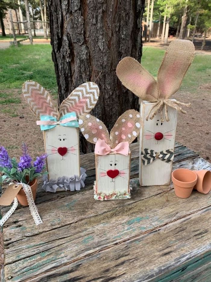 une idée de déco de paques diy avec des lapins élaborés de bois et de carton devant un grand arbre déco de pâques extérieure
