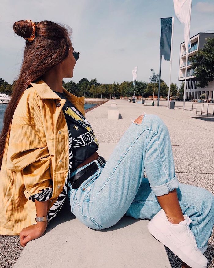 une tenue streetwear femme avec jean blue clair baskets blanches et une veste jaune