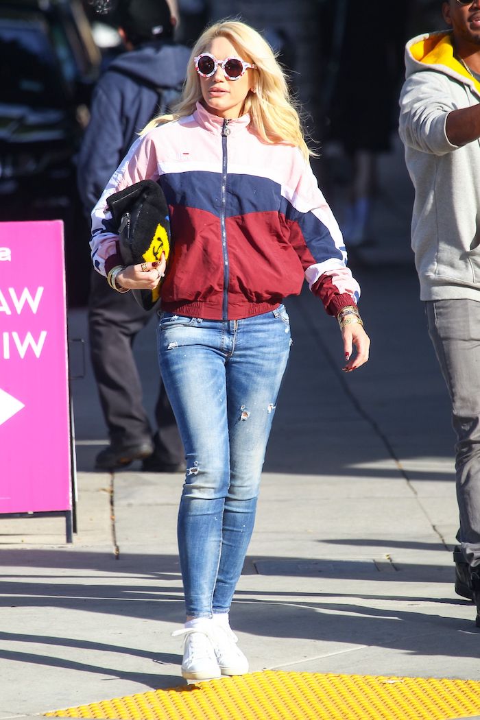 blond woman dressed in sporty american jacket and bleached jeans