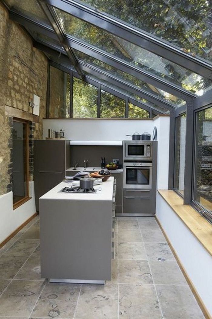 aménagement veranda 15m2 souus un toit en verre et des meubles et appareils a cuisson modernes cuisine dans une véranda