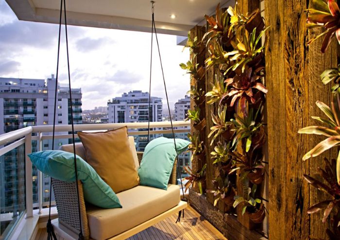 balançoire suspendue et mur végéta de poutres en bois avec des plantes dans les interstices revetement terrasse bois