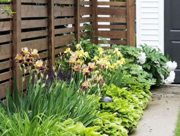 barrierre en palette ou autres planches de bois recyclées cacher bordure de jardin cour maison
