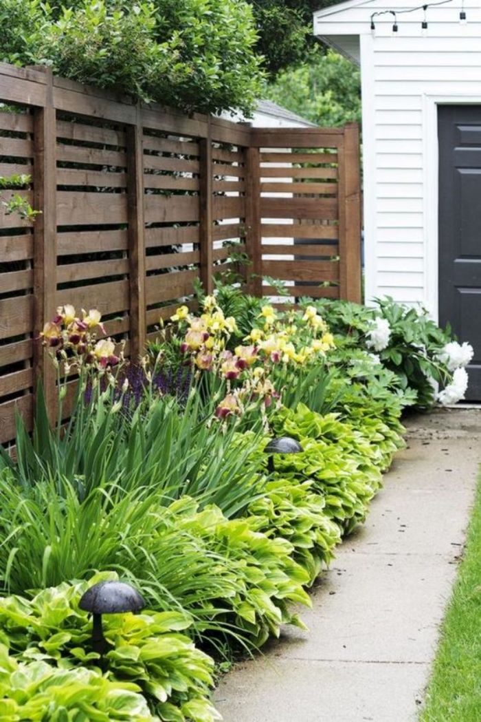 barrierre en palette ou autres planches de bois recyclées cacher bordure de jardin cour maison