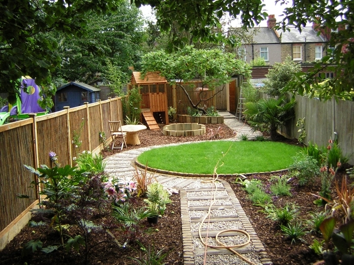 chemin galets blancs pierres aménager son jardin gazon jardin forme ronde cloture bois plantes vertes