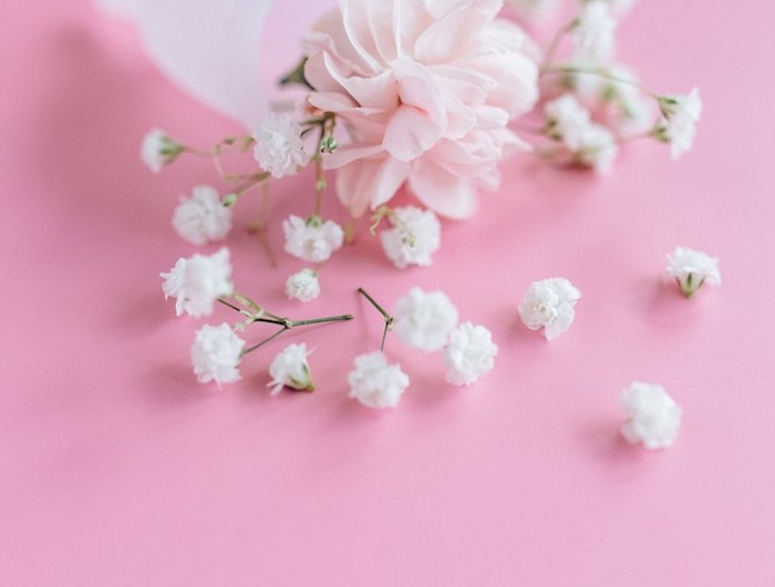 coupe menstruelle blanche une fleur rose dedans et brins de muguet persemés