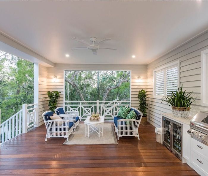 des chaises blanches et une table basse sur un sol en bois foncé idée deco veranda